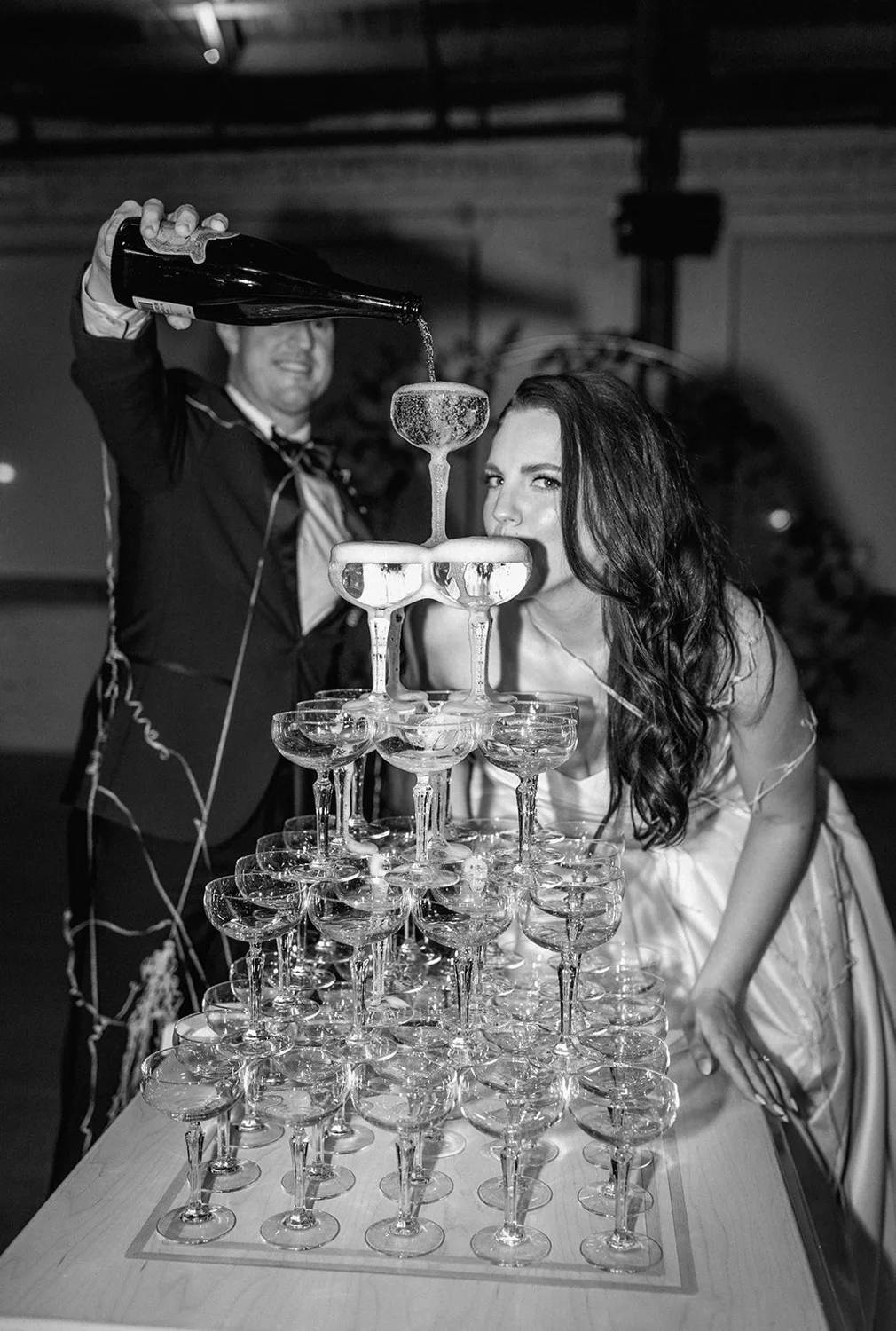Newlyweds pouring a champagne tower